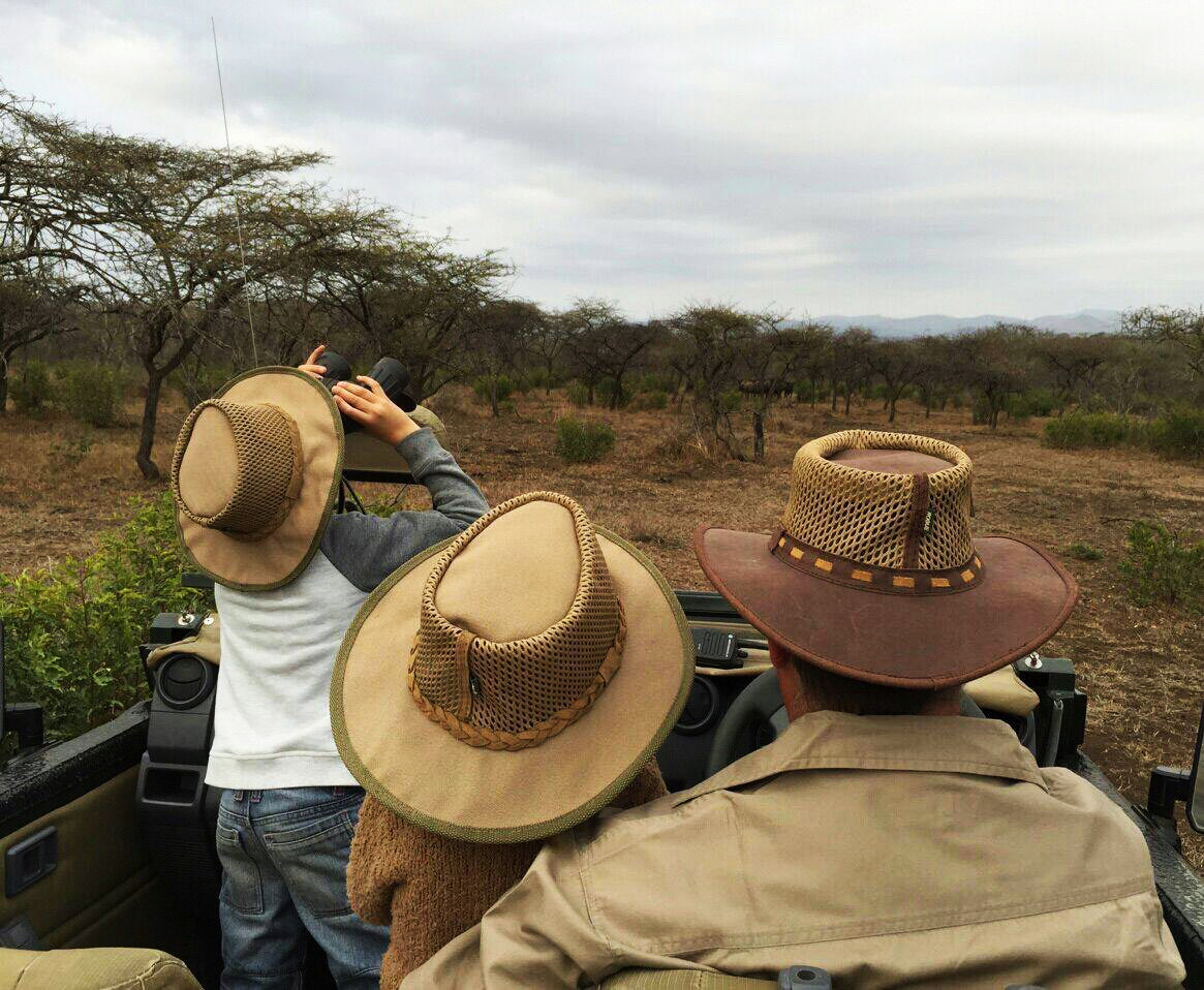 Family on safari wearing leather hats